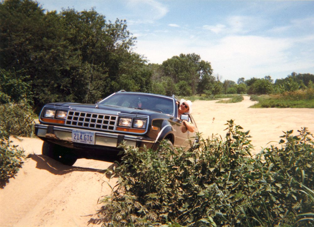 An Eagle wagon climbing a sandy trail through brush
