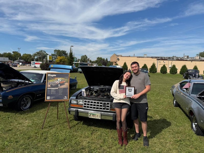 The owners with the Croatian Club Choice plaque in front of the Eagle, hood up, at the Orphan Car Show in Joliet
